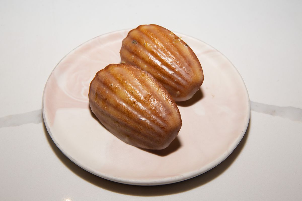 Two madeleines sit on a pink plate