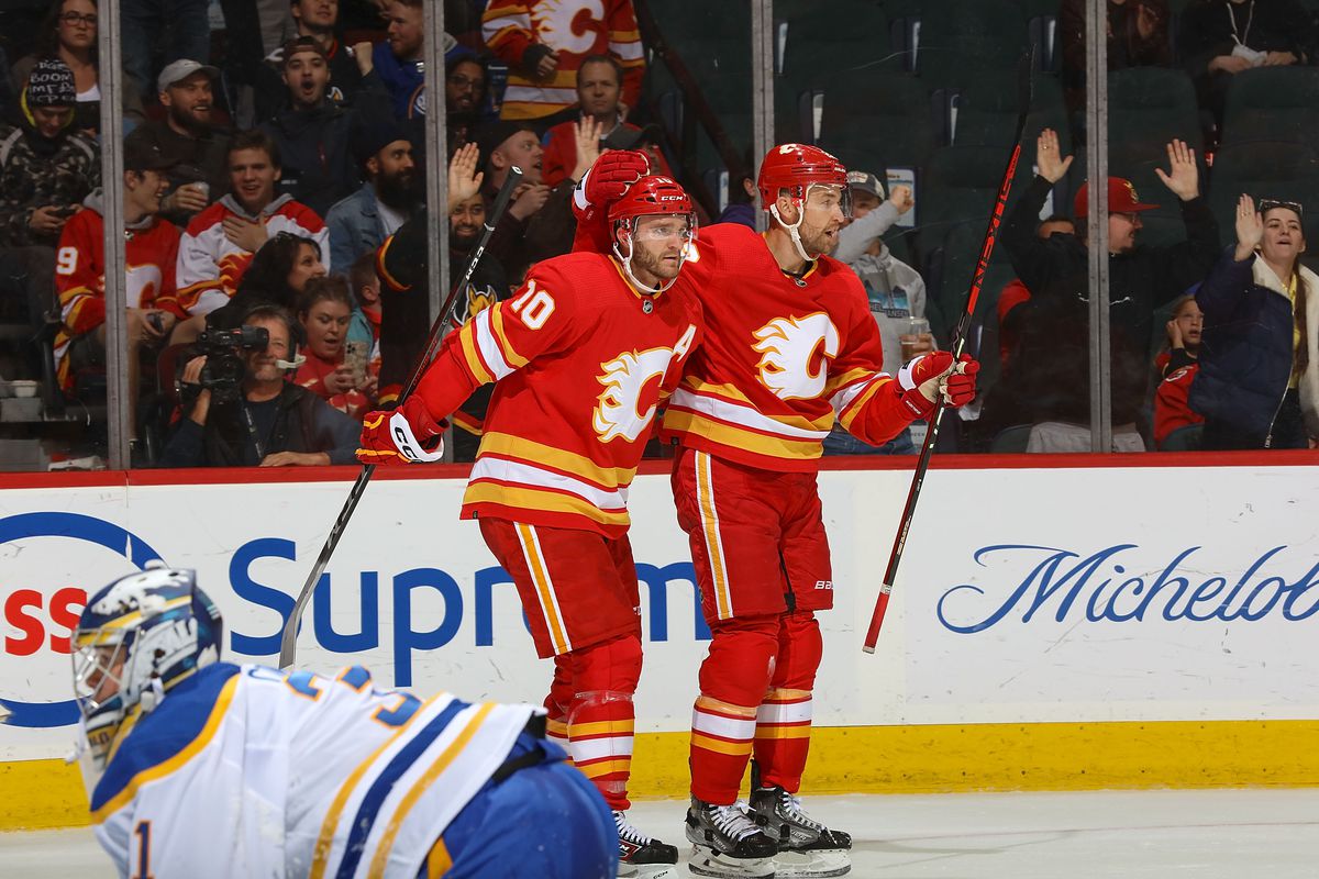 Trevor Lewis of the Calgary Flames celebrates with teammate Jonathan Huberdeau after a goal against the Buffalo Sabres at Scotiabank Saddledome on October 20, 2022 in Calgary, Alberta, Canada.