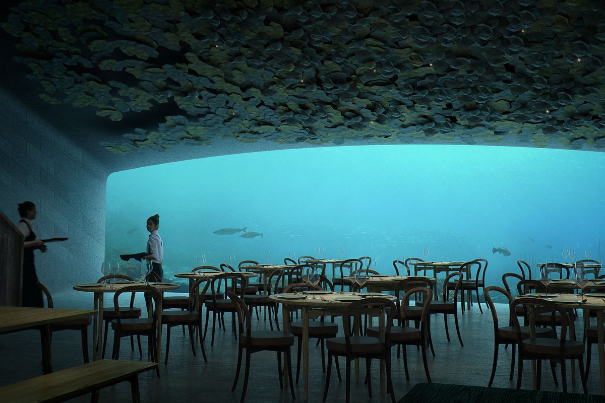 Rendering of interior of underwater restaurant with huge panoramic window looking into ocean. 