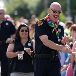 Salt Lake City Police Chief Chris Burbank hands out stickers during the 2015 Utah Pride Festival Parade in Salt Lake City on Sunday, June 7, 2015. Burbank resigned Thursday, June 11, 2015.