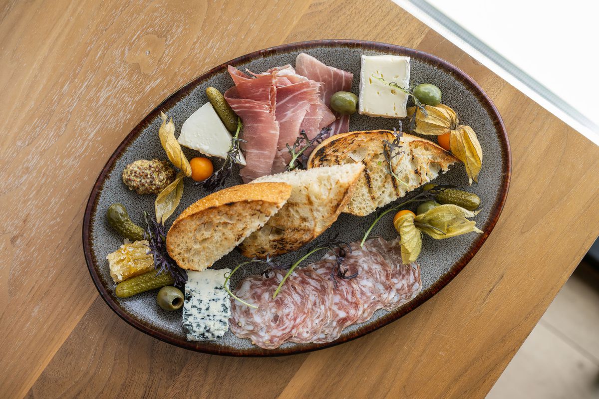 Charcuterie plate at Restaurant 917 with sliced meats, grilled bread, and accoutrement.