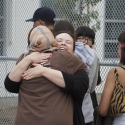 Two women comfort each other, Friday June 7, 2013 in Santa Monica, Calif., after a gunman with an assault-style rifle killed at least six people in Santa Monica before police shot him to death in a gunfight in the Santa Monica College library, authorities said. 