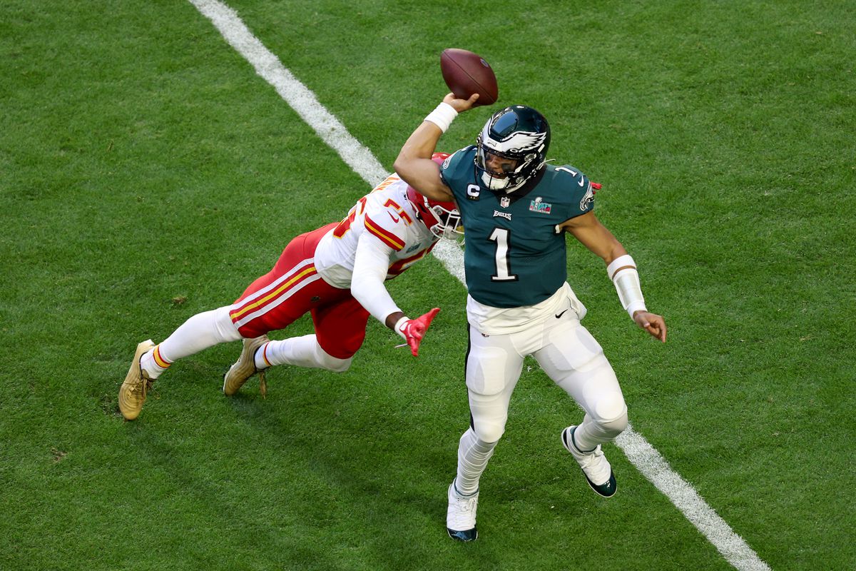 Jalen Hurts of the Philadelphia Eagles throws a pass against Frank Clark of the Kansas City Chiefs during the first quarter in Super Bowl LVII at State Farm Stadium on February 12, 2023 in Glendale, Arizona.