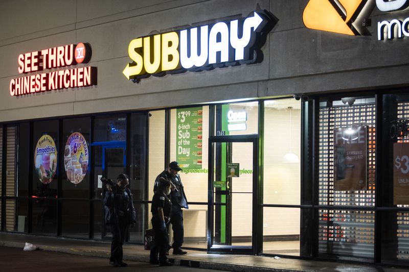 Chicago police investigate in a Subway at 6718 S. Stony Island Ave., where police said four teens were shot Sunday night as they stood in the parking lot of the Grand Crossing restaurant.