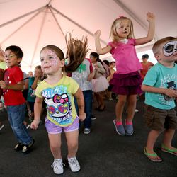Elaina Conover, in yellow, Afton Horne, in pink, and Porter Keddington, in turquoise, participate in a dance contest at the Farmington Family Night as part of the 9th annual Be Well Utah outside of the Farmington Health Center in Farmington on Monday, Aug. 21, 2017.