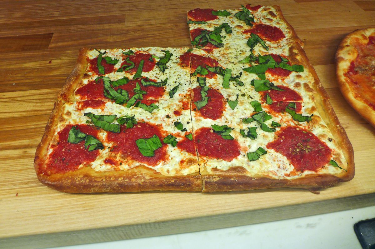 A tray of square slices splotched with fresh mozzarella.