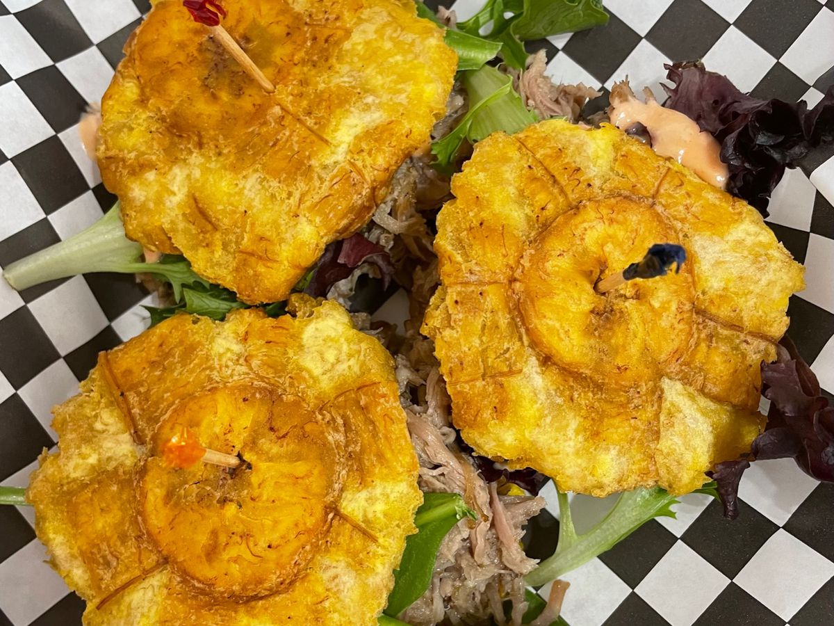 Crunchy fried plantains act as the bread for this pork sandwich called jibarito.