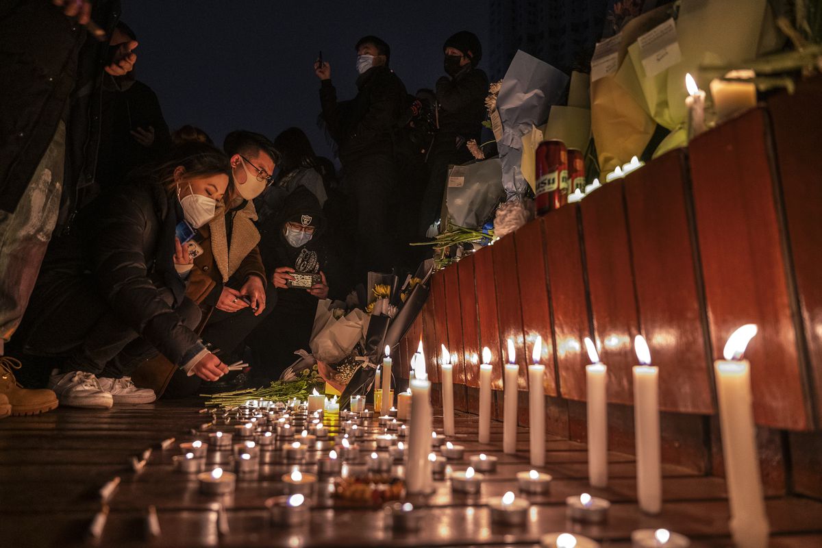 Protestors light candles at a memorial protest against China’s Covid-19 restrictions.