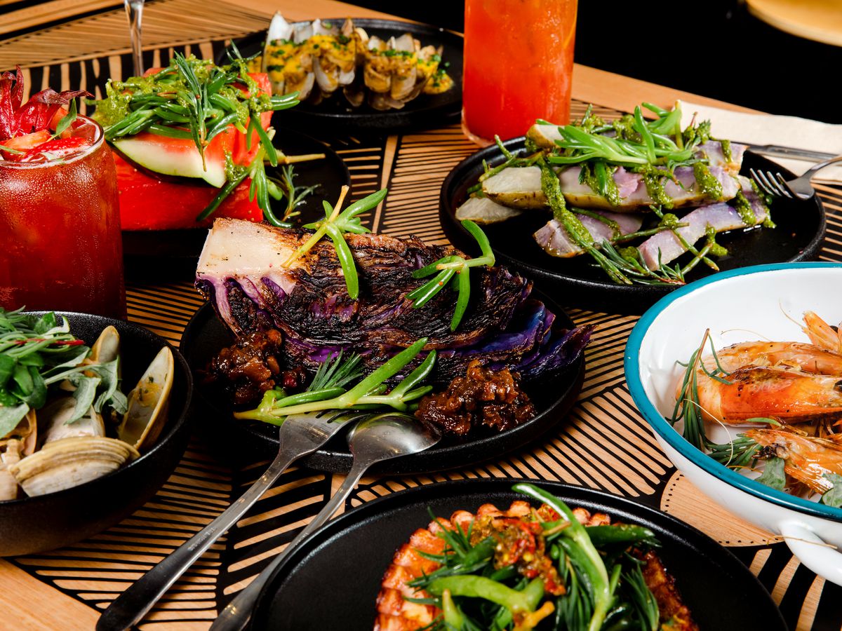 A table full of colorful dishes, including quartered purple cabbage and various seafood items.