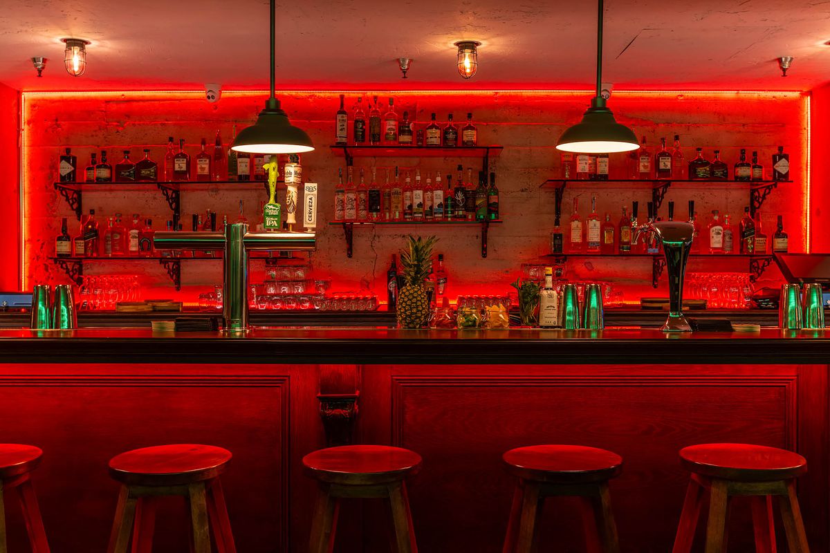 The bar area with red lighting at Bar CDMX.