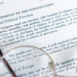 The First Amendment to the Constitution is shown on the page of a history book.