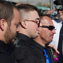 Braydon Brotherson stands with his father, Jeff Brotherson, after they helped to place the casket of their brother and son — West Valley police officer Cody Brotherson — into the hearse following funeral services at the Maverik Center in West Valley City on Monday, Nov. 14, 2016.