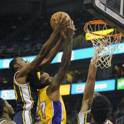 Utah Jazz power forward Derrick Favors (15) goes for a rebound over Los Angeles Lakers center Jordan Hill (27) during a game at EnergySolutions Arena on Friday, Dec. 27, 2013.