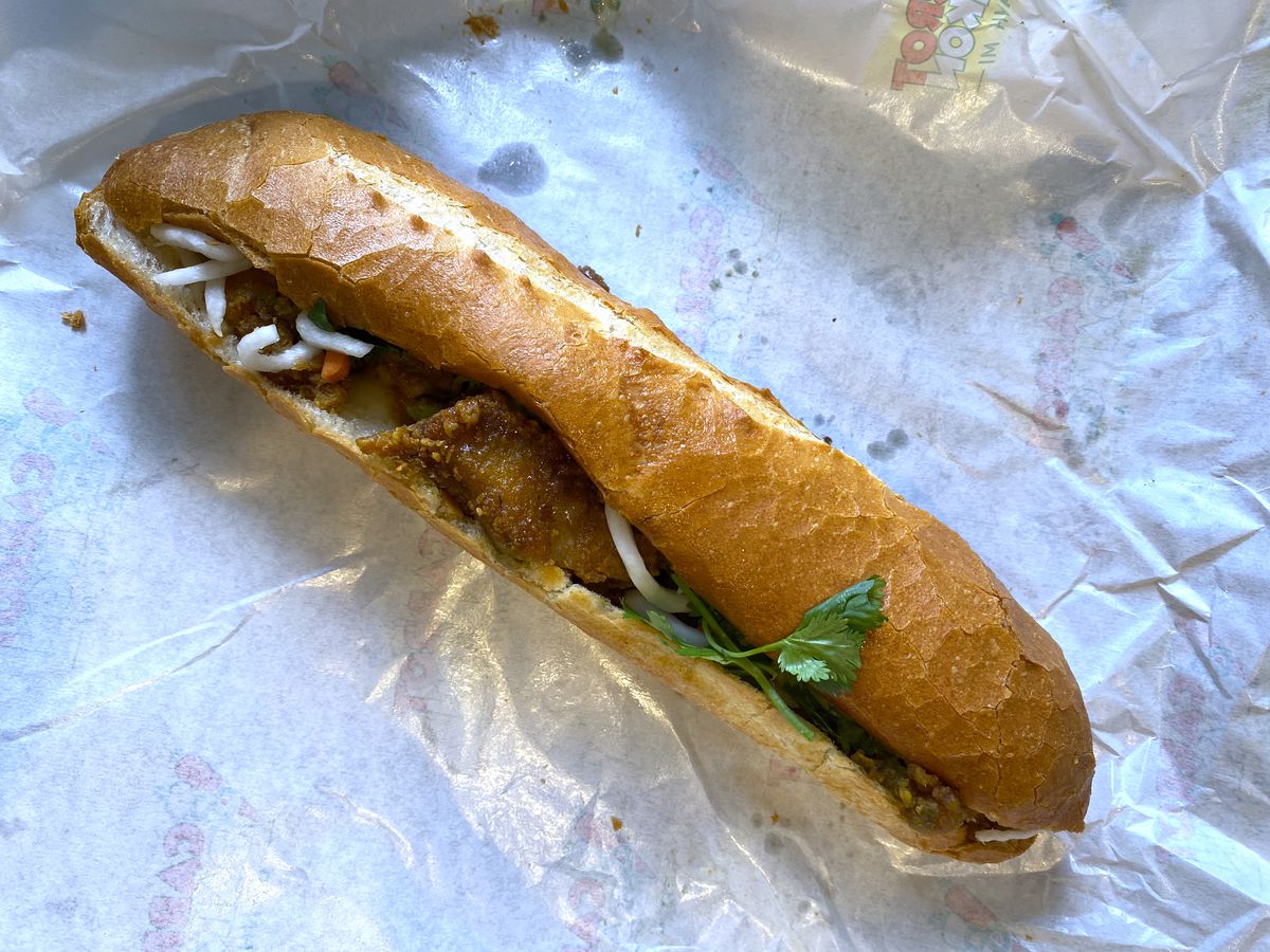A golden baguette filled with fried fish and cilantro at Carrots &amp; Daikon in Garden Grove 