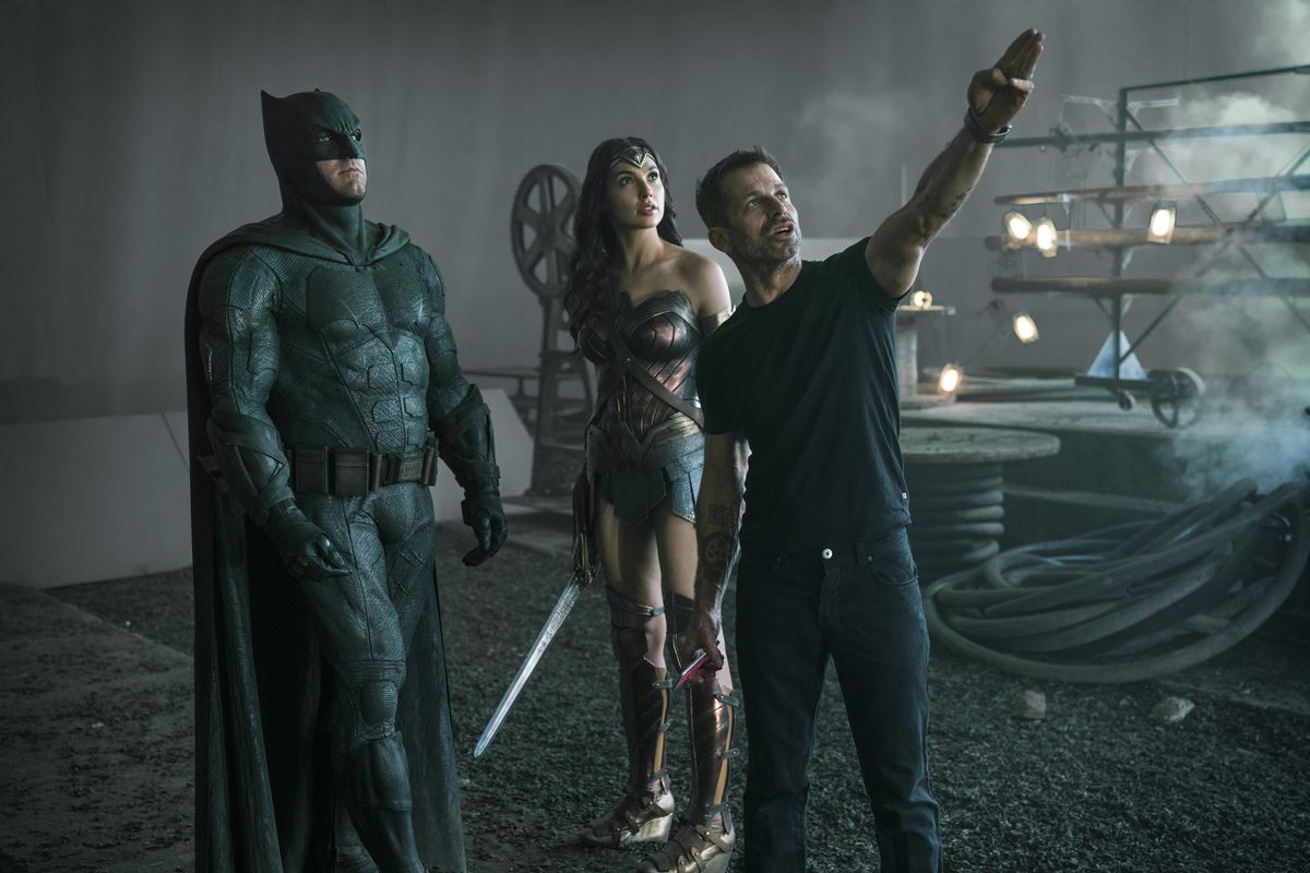 Director Zack Snyder, speaking with Ben Affleck and Gal Gadot in character as Batman and Wonder Woman. 