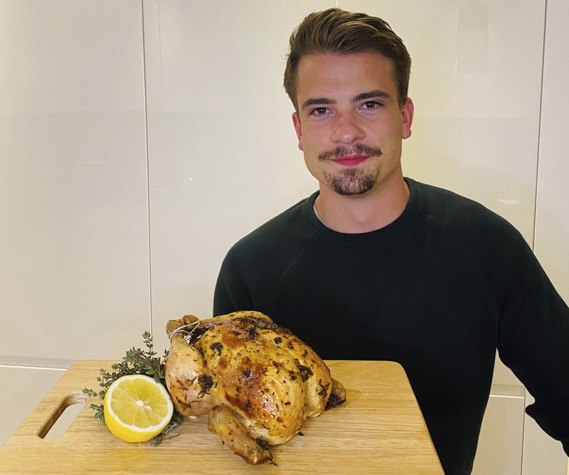 Harry Heal is photographed holding a roasted chicken. Heal, a 26-year-old who lives in Dubai, is one of the burgeoning celebrity chefs on TikTok.