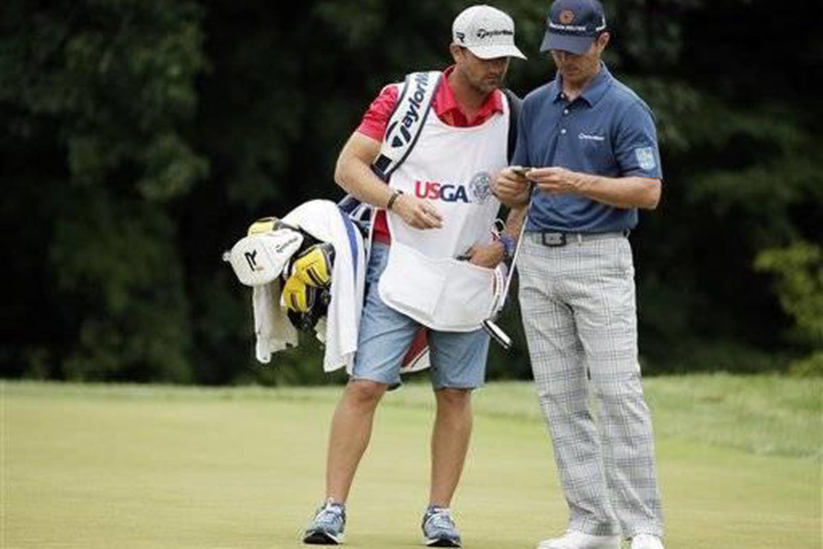 Mike Weir, of Canada, looks over his notes with his caddie on the 12th hole during the first round of the U.S. Open golf tournament at Merion Golf Club, Thursday, June 13, 2013, in Ardmore, Pa. (AP Photo/Charlie Riedel)