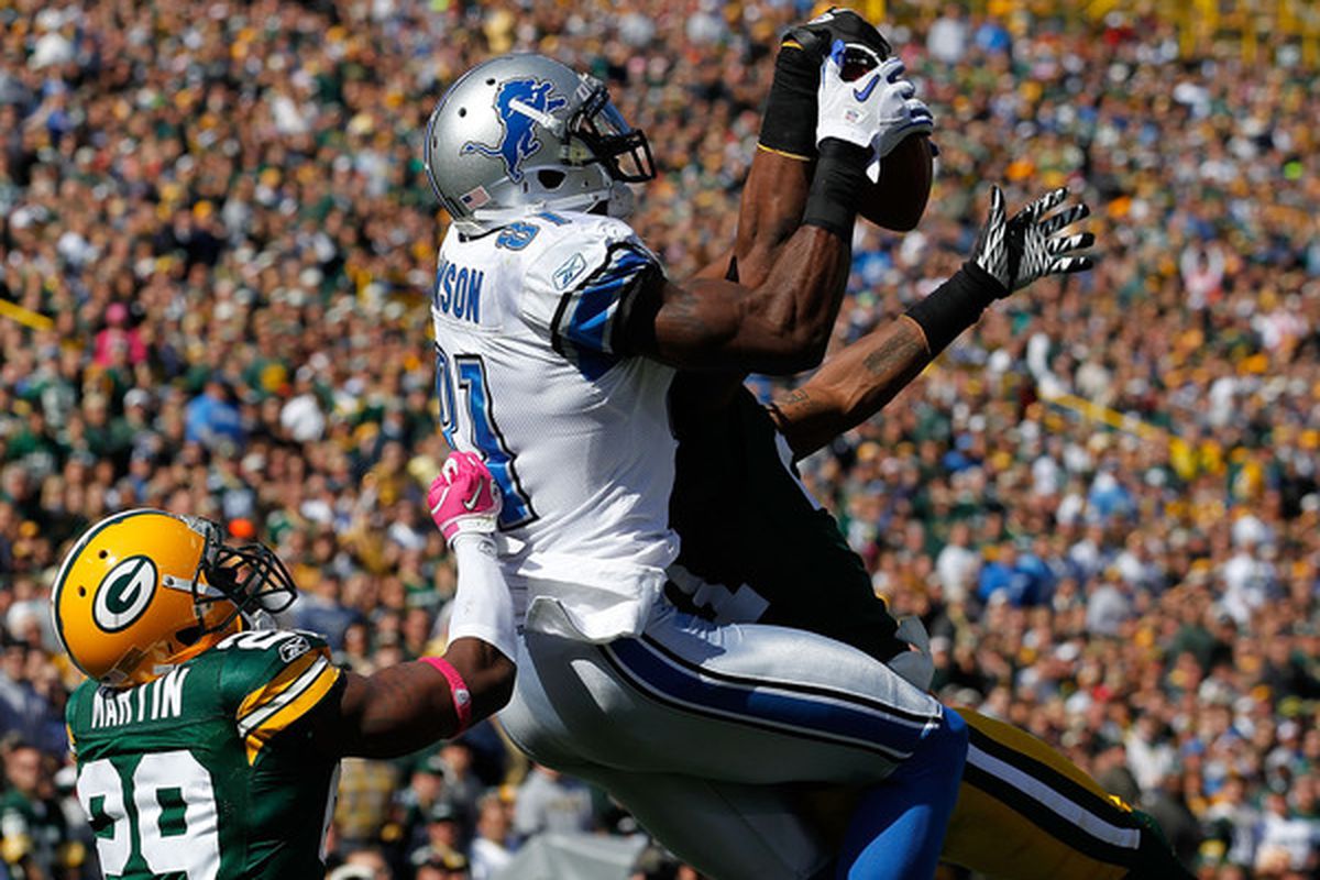 Calvin Johnson makes a leaping touchdown catch over two Packers defenders.