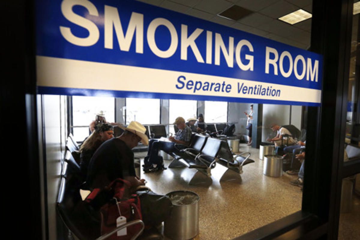 FILE: Travelers use a smoking room at Salt Lake City International Airport, Monday, Aug. 3, 2015.