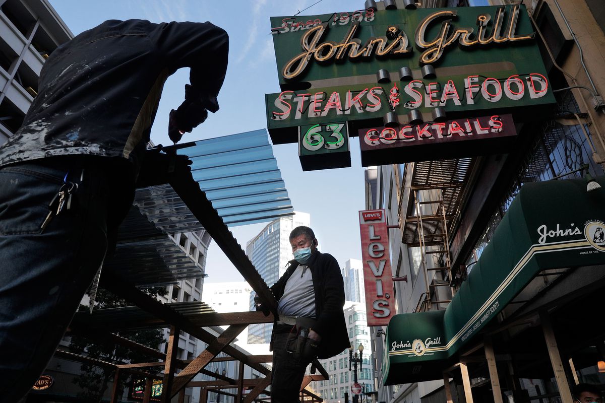 Workers build an exterior dining area at John’s Grill in San Francisco, Calif., on Tuesday, November 10, 2020. Citing a concerning surge in cases and a rise in the average testing positivity rate in the city to 1.28%, Mayor London Breed announced a set o