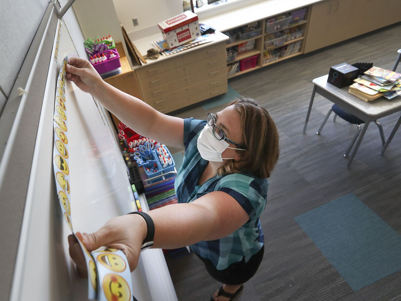 Third grade teacher Tiffany Rudelich puts magnetic smiley face strips on the white board in her classroom at the newly constructed Midvalley Elementary School, 217 E. 7800 South, in Midvale on Monday, Aug. 10, 2020.