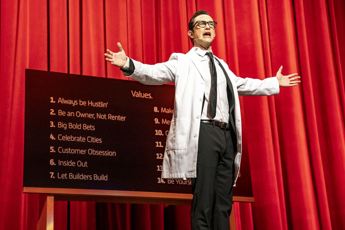 Travis Kalanick, interpretado por Joseph Gordon-Levitt, se para en el escenario frente a una lista de valores de Uber.