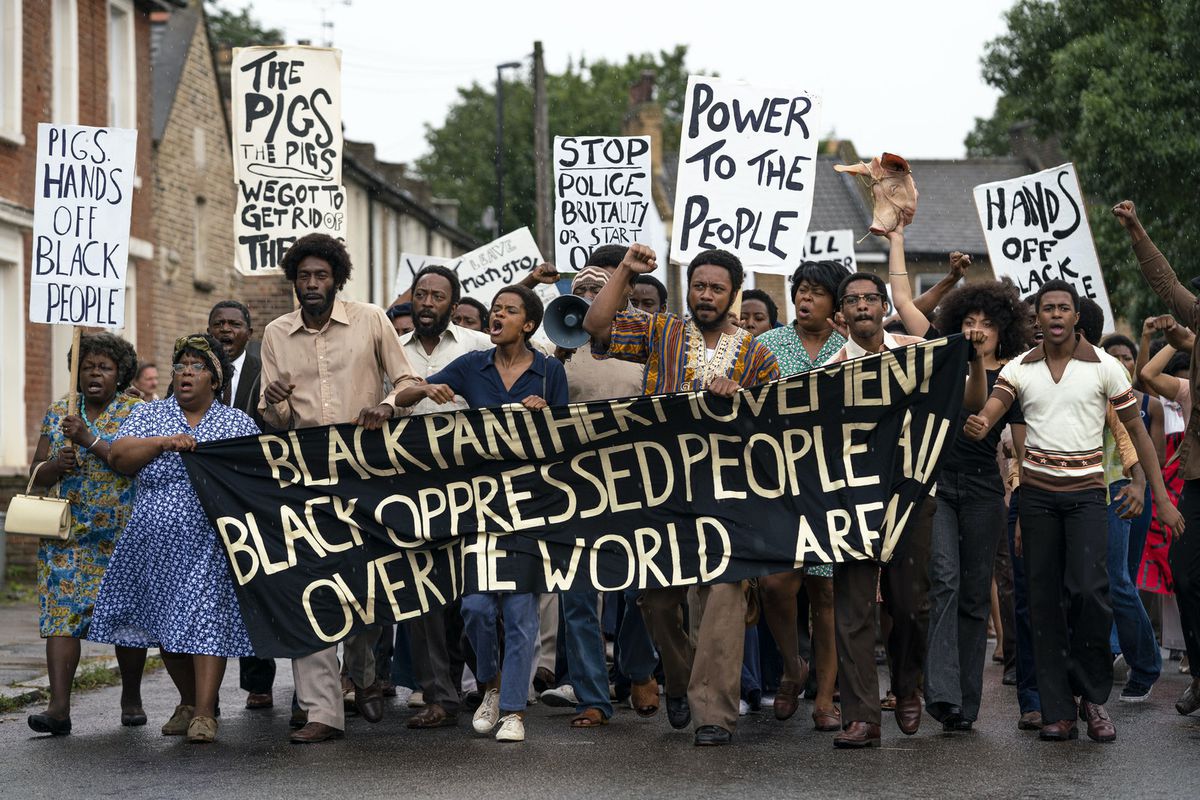 A large group of black protesters carry a Black Panther banner in Steve McQueen's Small X series film Mangrove
