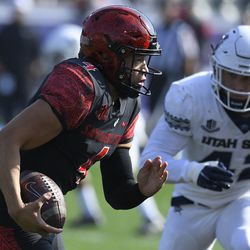 San Diego State quarterback Jordon Brookshire (4) runs away from Utah State defensive end Nick Heninger (42) in the first half during an NCAA college football game for the Mountain West Conference Championship, Saturday, Dec. 4, 2021, in Carson, Calif. 