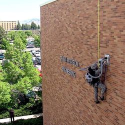 Annie Smith, a junior at USU in the ROTC program, climbs the side of the Dean F. Peterson Engineering Building with the new climbing device in Logan Tuesday morning, May 29, 2012.