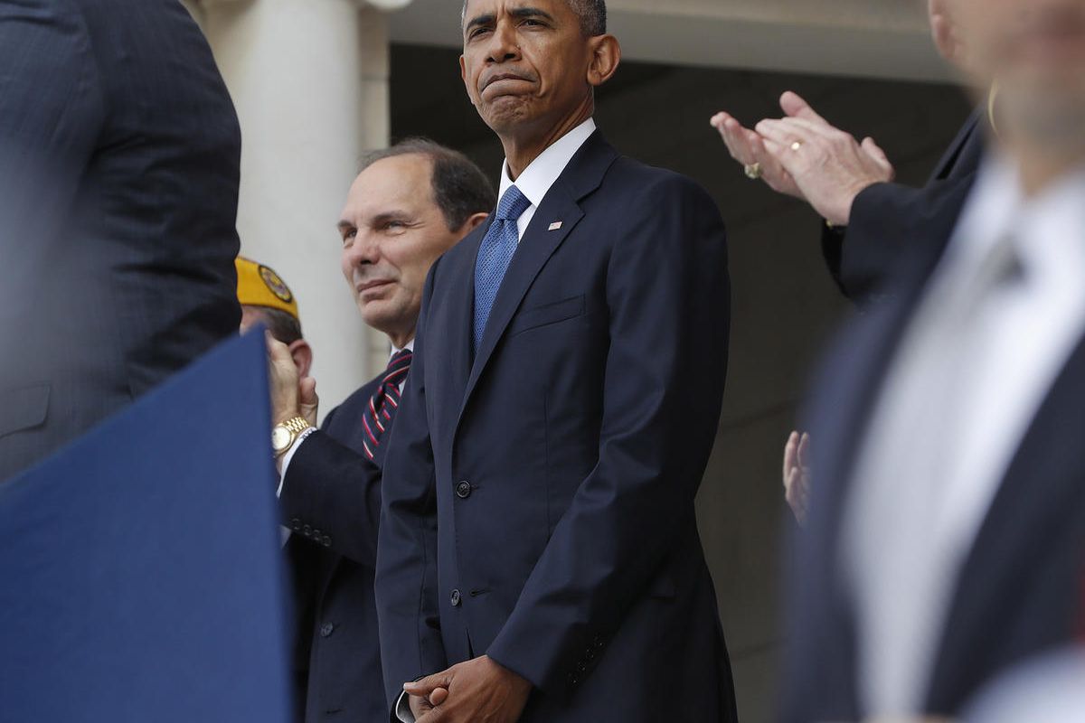 President Barack Obama, accompanied by Veterans Affairs Secretary Robert A. McDonald, receives applause after speaking at a Veteran Day ceremony in the Memorial Amphitheater at Arlington National Cemetery in Arlington, Va., Friday, Nov. 11, 2016.  (AP Pho