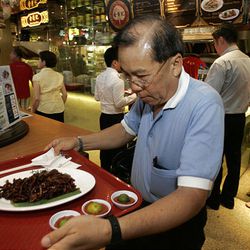 In this photo taken on Jan. 14, 2010, a customer carries his food at Lot 10 Hutong food court in Kuala Lumpur, Malaysia.