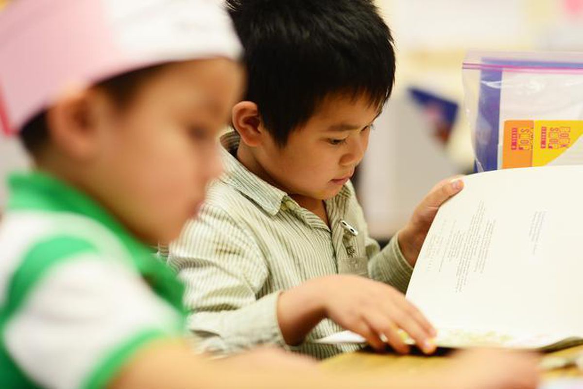 A kindergartner flips the page while reading in class at Crawford Elementary in Aurora. (Denver Post file)