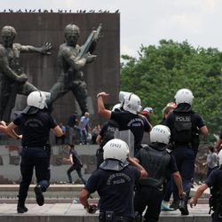 Police chase protesters as Turkish riot police spray water cannon at demonstrators who remained defiant after authorities evicted activists from an Istanbul park, making clear they are taking a hardline against attempts to rekindle protests that have shaken the country, in city's main Kizilay Square in Ankara, Turkey, Sunday, June 16, 2013.