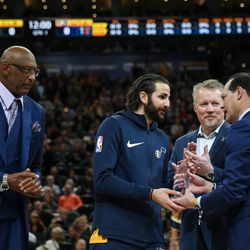 Utah Jazz guard Ricky Rubio, second from left, is presented with the NBA Cares Community Assist Award by NBA Cares ambassador Bob Lanier, NBA board of governors representative for the Utah Jazz's Greg Miller and physician Ronald Navarro, left to right, at Vivint Arena in Salt Lake City on Saturday, Dec. 30, 2017.