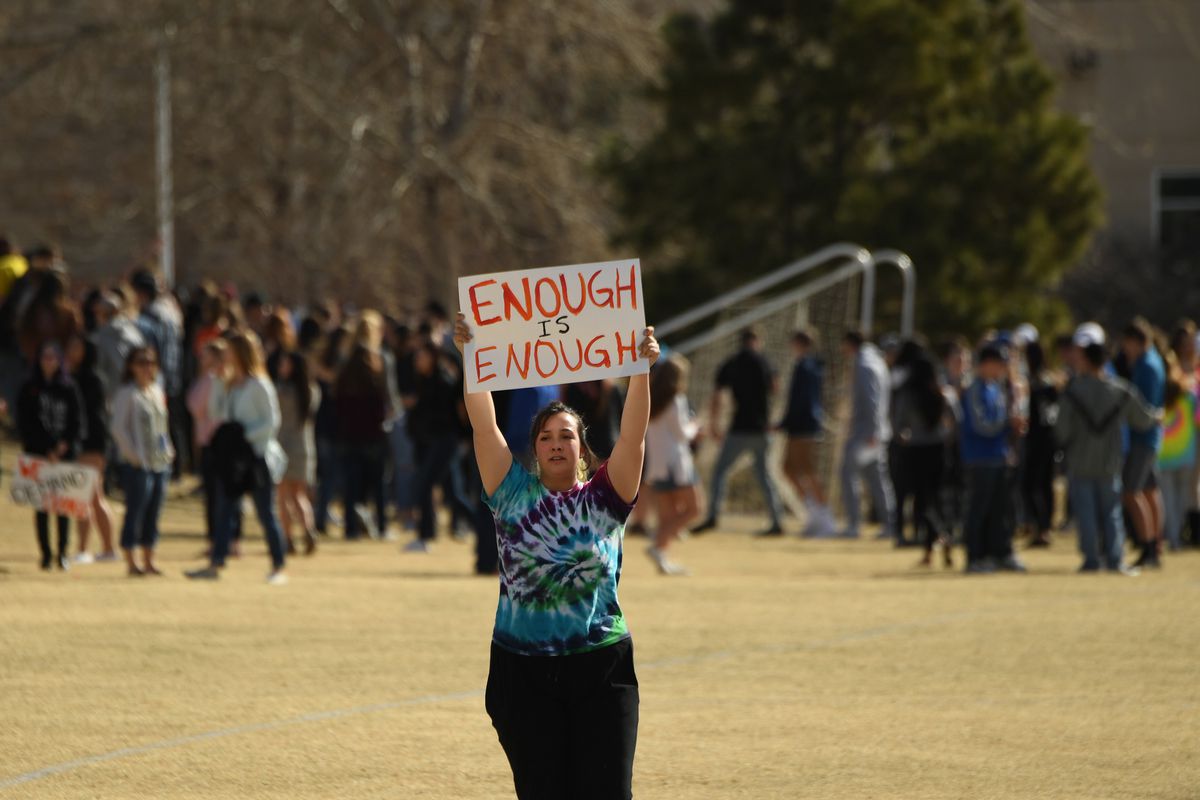 A student at Columbine High School holds a sign reading “Enough is Enough” during a walkout after the Parkland, Florida, school shooting.