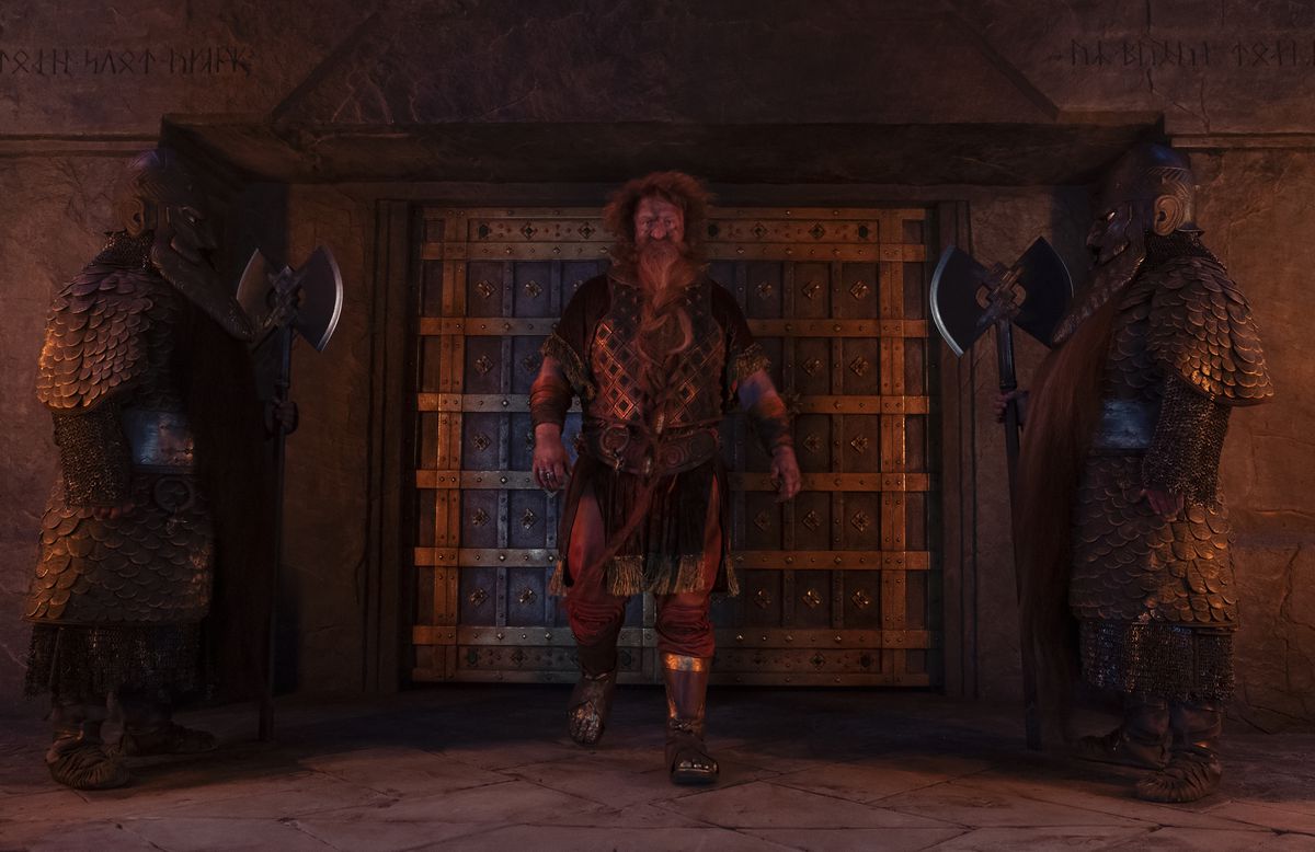 Durin standing in front of a set of double doors with two dwarven guards to the side