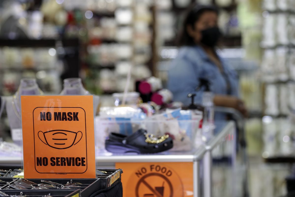 A store in Los Angeles has posted orange signs reading, “No mask, no service,” in mid-July, 2022.