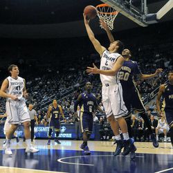 BYU guard Kyle Collinsworth (5) goes in for a reverse layup as Prairie View A&M Panthers forward Jules Montgomery (20) defends during a game at the Marriott Center in Provo on Wednesday, Dec. 11, 2013.