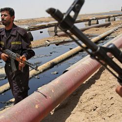  In this June 22, 2008 file photo, Iraqi police officers protecting oil installations secure an oil pipeline from the Rumailah refinery, north of Basra, Iraq. A senior Iraqi official on Wednesday said his country expects to ramp up oil production to 4.5 million barrels per day by the end of next year from around 3.5 million barrels now, thanks to work by a handful of international oil companies developing the country's prized oil and gas fields.