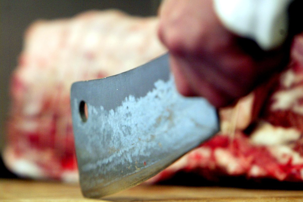 A butcher prepares cuts of Aberdeen Angus beef in his London shop in 2003.