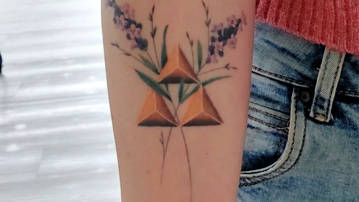 An arm with a Triforce tattoo and some flowers