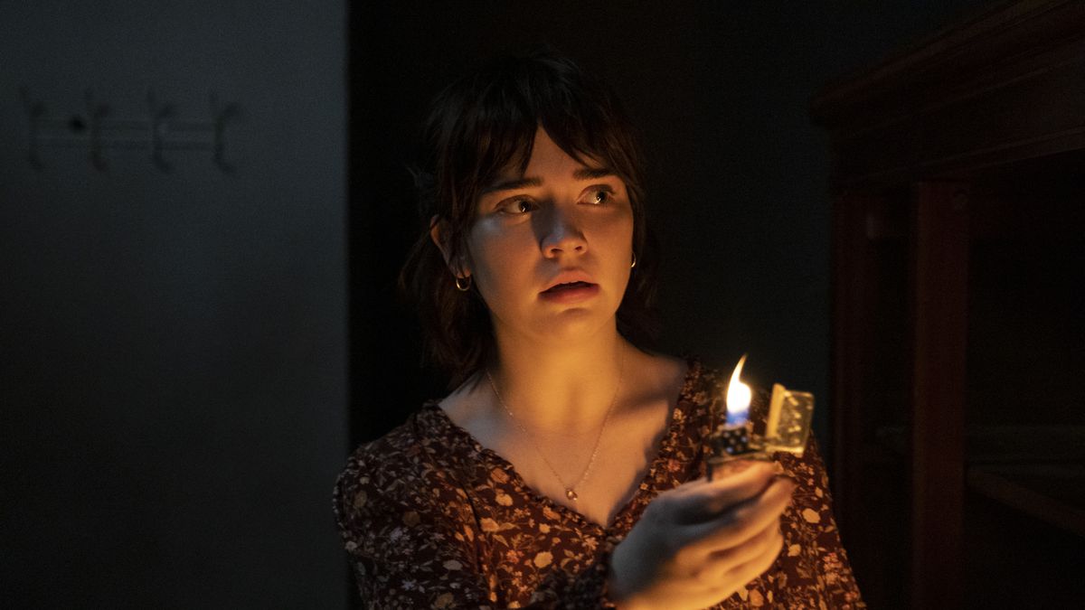 Sophie Thatcher as Sadie Harper holding a lighter to illuminate a dark hallway in The Boogeyman