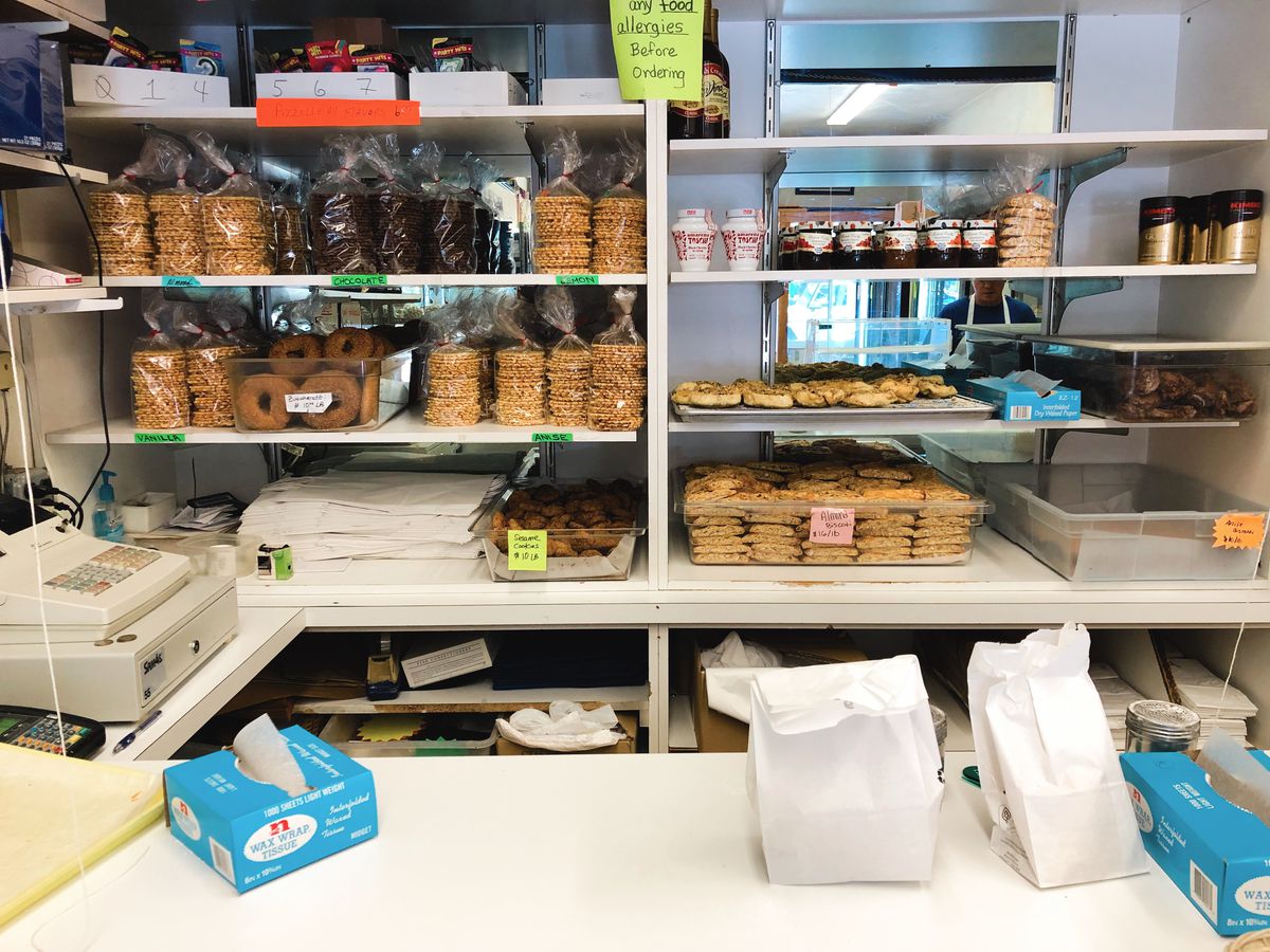 An interior shot of Maria’s Pastry Shop. Packaged cookies and other treats rest on the shelves behind the till.