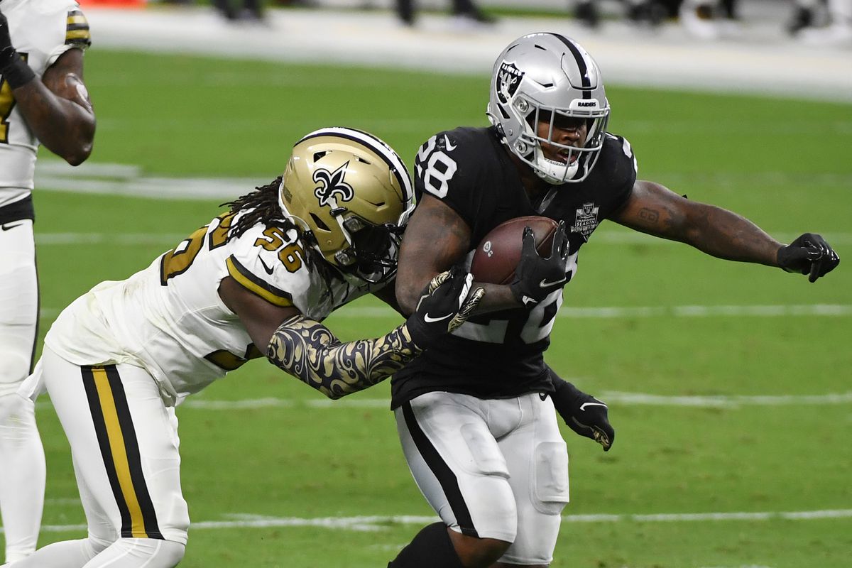 Running back Josh Jacobs of the Las Vegas Raiders is tackled by outside linebacker Demario Davis of the New Orleans Saints during the first half of the NFL game at Allegiant Stadium on September 21, 2020 in Las Vegas, Nevada.