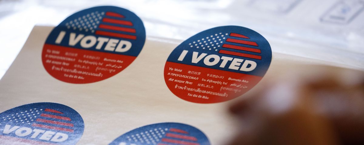 Close up shot of red, white, and blue stickers that read “I VOTED.”
