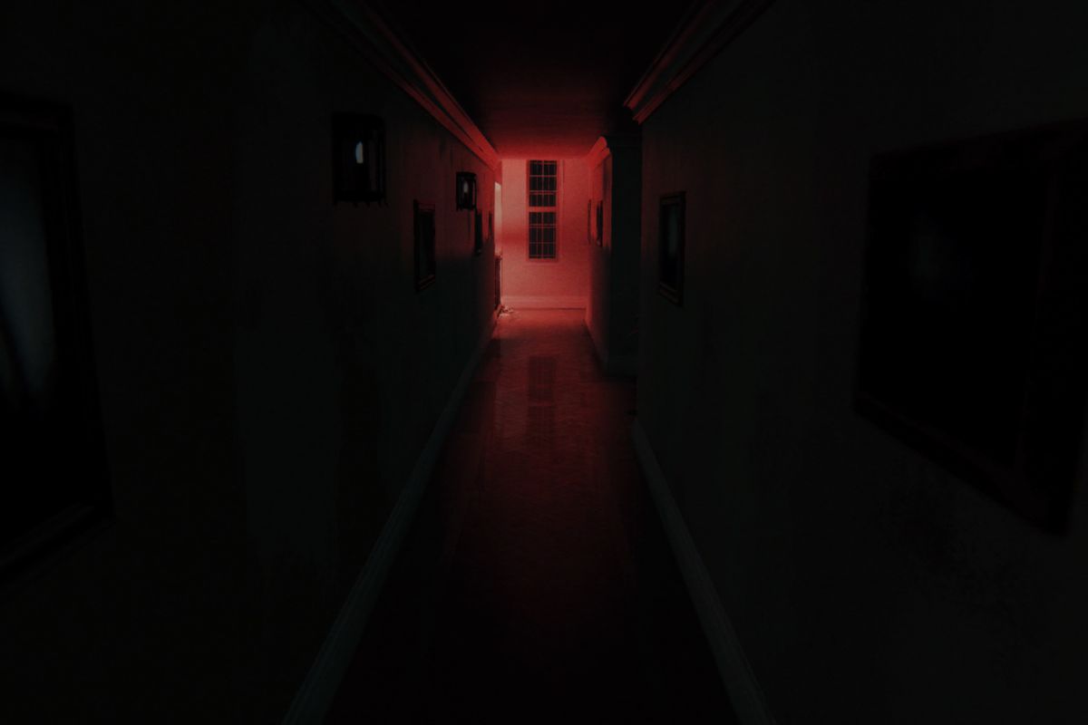 A dark hallway in P.T., lit by red light at the end, in a suburban home