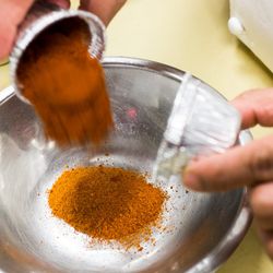 To make the chili oil, the paprika, chili power, and cayenne pepper are added to a mixing bowl.