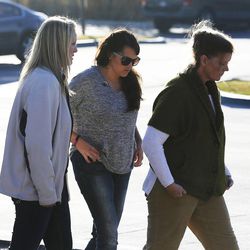 Amy Fugal, middle, is accompanied as she visits the scene where a body was found in the Jordan River at 3300 South in Salt Lake City, Monday, Dec. 1, 2014. Fugal is a cousin of missing Murray woman Kayelyn Louder.