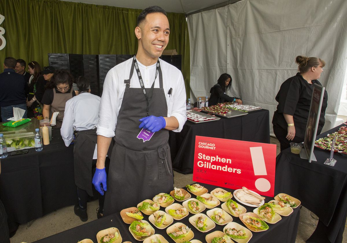 A chef smiles in front of dozens of samples.
