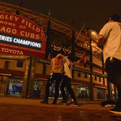 Fans celebrate outside Wrigley Field in Chicago early Thursday, Nov. 3, 2016, after the Chicago Cubs defeated the Cleveland Indians 8-7 in Game 7 of the baseball World Series in Cleveland. (AP Photo/Matt Marton)